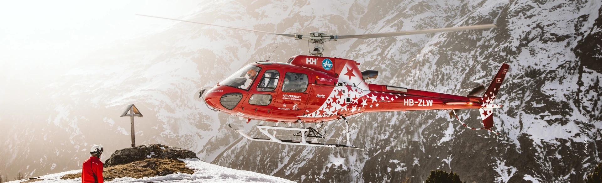 Fly For Fun Flugsicherheit: Rettungshubschrauber bei der Landung in winterlichen Hochgebirge mit Bergretter