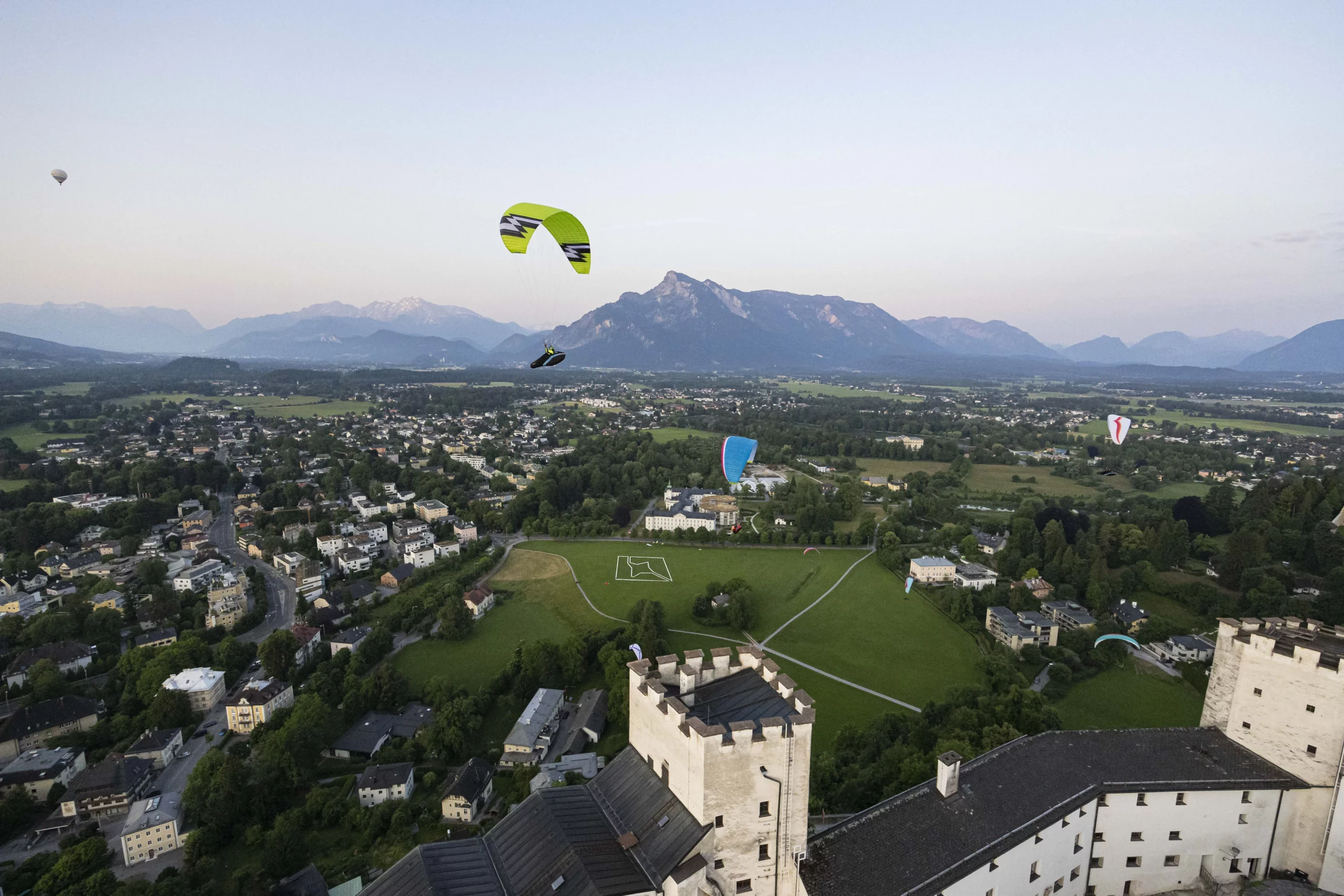 Event: Festungsflug 2023 - Paragleiter soaren über der Festung mit Blick zur Festungswiese sowie zum Untersberg