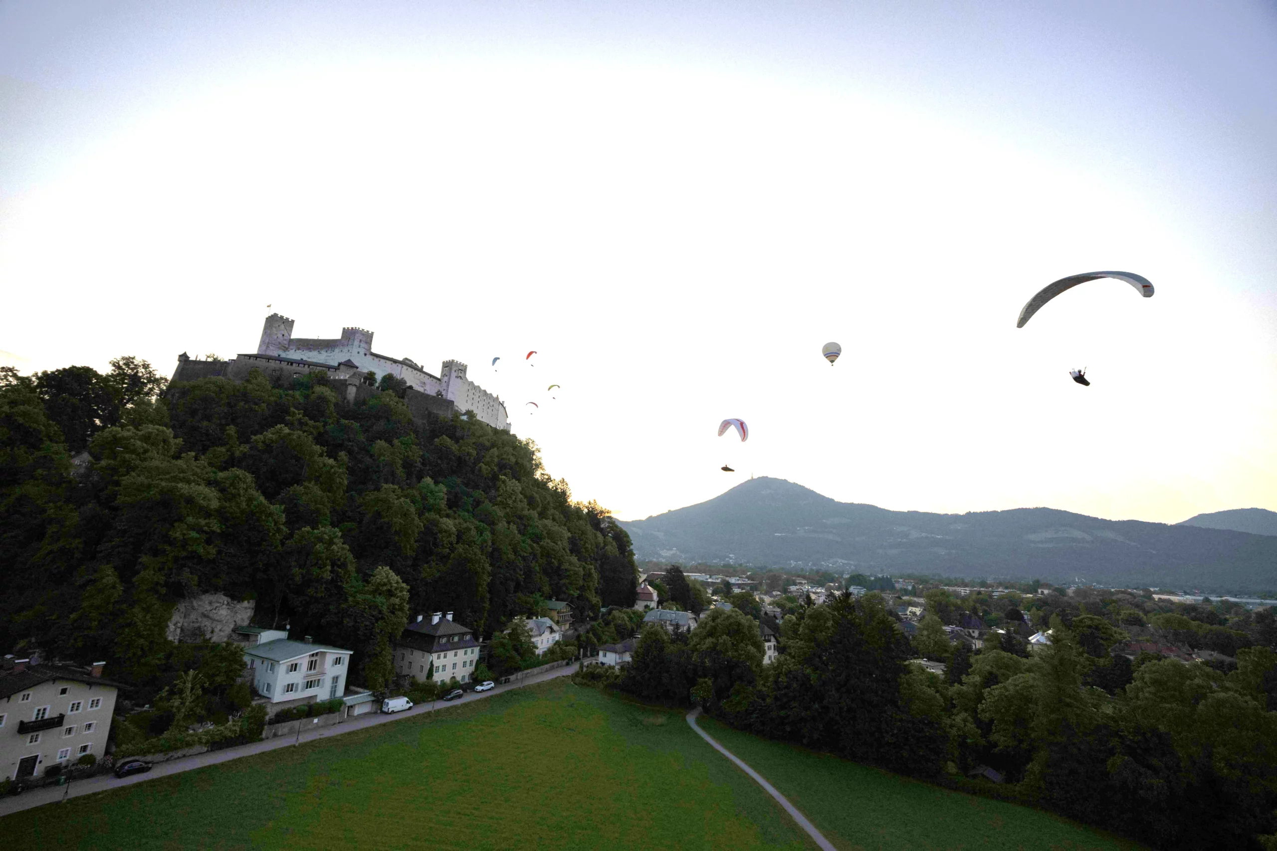 Event: Festungsflug 2023 - Paragleiter im ersten Licht des Tages über der Festung mit Blick zum Gaisberg